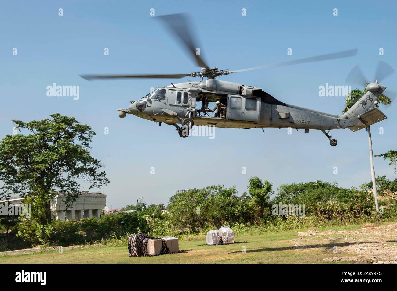 Un hélicoptère MH-60S Seahawk affecté à la "Dragon" les baleines de la mer de l'Escadron d'hélicoptères de combat 28, joint à la navire-hôpital USNS Comfort (T-AH 20), des terres à un site de traitement médical temporaire dans la région de Port-au-Prince, Haïti, 10 novembre 2019. Le confort est de travailler avec les partenaires gouvernementaux et de la santé en Amérique centrale, Amérique du Sud, et les Caraïbes pour fournir des soins sur le navire et dans les sites médicaux, aide à relâcher la pression sur les systèmes médicaux, y compris ceux qui sont accablés par une augmentation des migrants transfrontaliers. (U.S. Photo par marine Spécialiste de la communication de masse 2e classe Bobby J Tr Banque D'Images