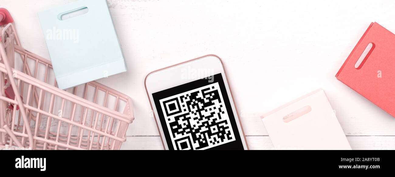 Résumé Les achats en ligne, paiement mobile avec QR code élément concept design, coloré panier, sac de papier sur la table en bois, l'arrière-plan, Vue de dessus télévision lay Banque D'Images