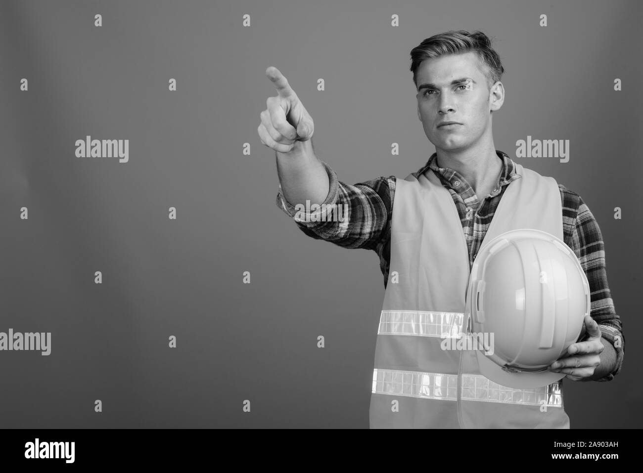 Portrait of young handsome man construction worker en noir et blanc Banque D'Images
