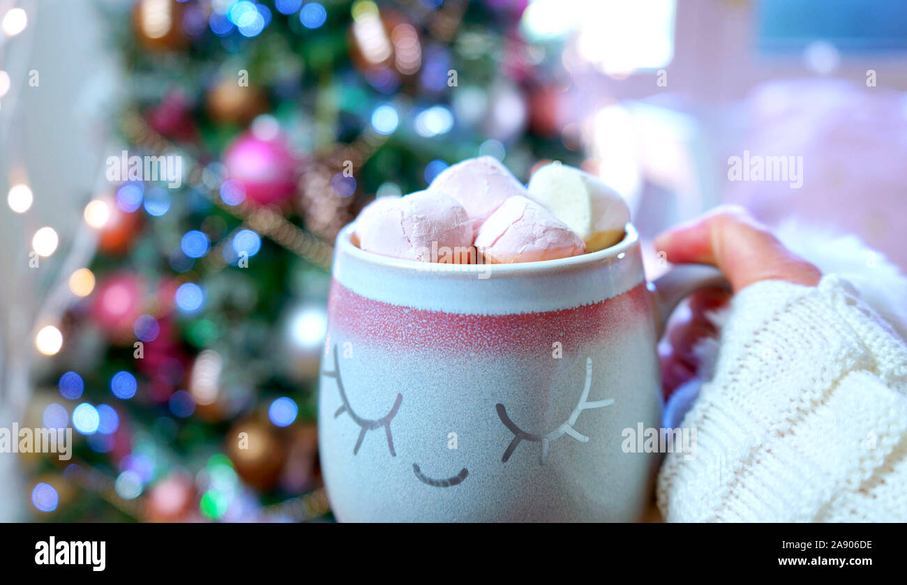 Femme tenant un chocolat chaud en face de tendance sur le rose et l'or rose boîte arbre de Noël. Banque D'Images