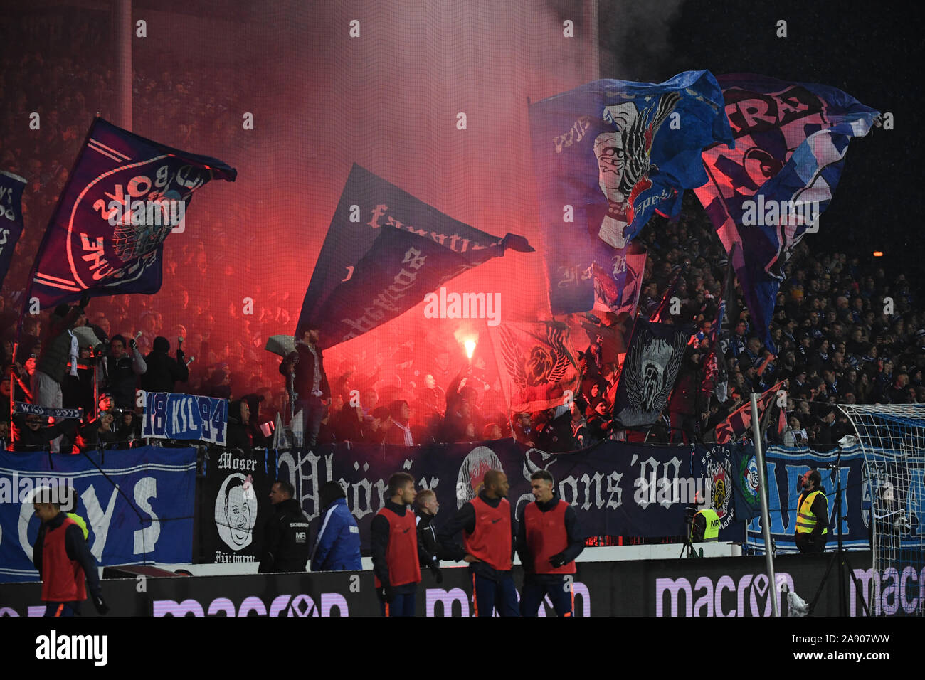 Karlsruhe, Allemagne. 11Th Nov, 2019. Soccer : 2ème Bundesliga, Karlsruher SC - Erzgebirge Aue, 13e journée dans le Wildparkstadion. Fans de Karlsruhe brûler pyro torches. Credit : Uli Deck/DPA - NOTE IMPORTANTE : en conformité avec les exigences de la DFL Deutsche Fußball Liga ou la DFB Deutscher Fußball-Bund, il est interdit d'utiliser ou avoir utilisé des photographies prises dans le stade et/ou la correspondance dans la séquence sous forme d'images et/ou vidéo-comme des séquences de photos./dpa/Alamy Live News Banque D'Images