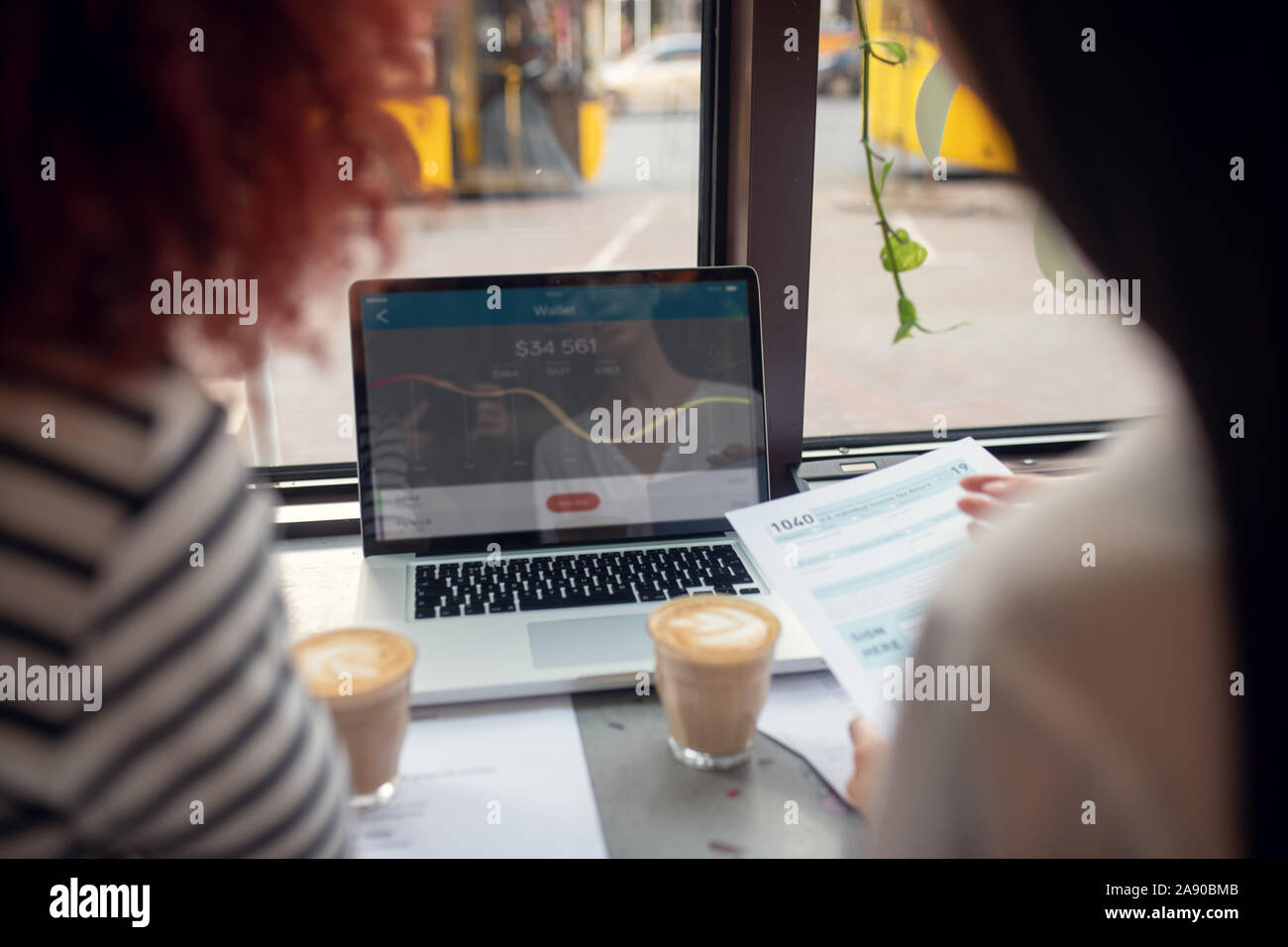 Businesswomen looking at laptop pendant le contrôle de taux de change Banque D'Images