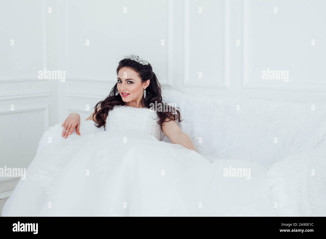 Mariée en robe de mariage assis sur le canapé Banque D'Images