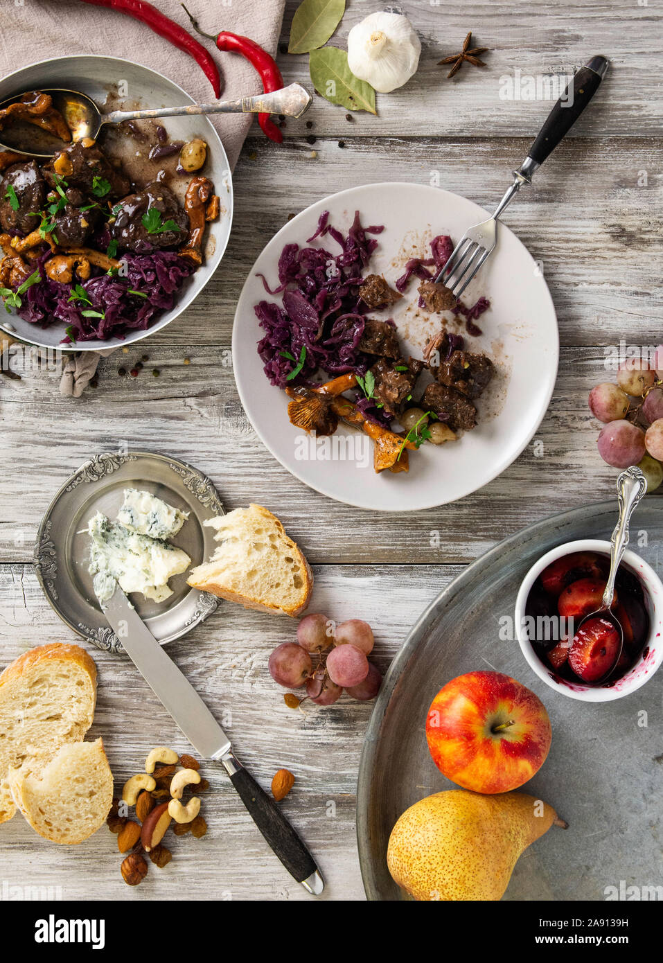 Plat de venaison sur la vieille table en bois, avec des fruits, du fromage et de la confiture de châtaignes, plat d'hiver traditionnel avec de la viande de chasse, piller Banque D'Images