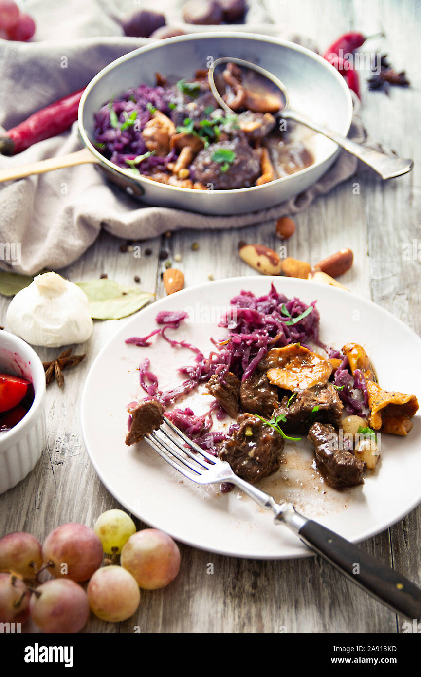 Plat de venaison sur la vieille table en bois, avec des fruits, du fromage et de la confiture de châtaignes, plat d'hiver traditionnel avec de la viande de chasse, piller Banque D'Images