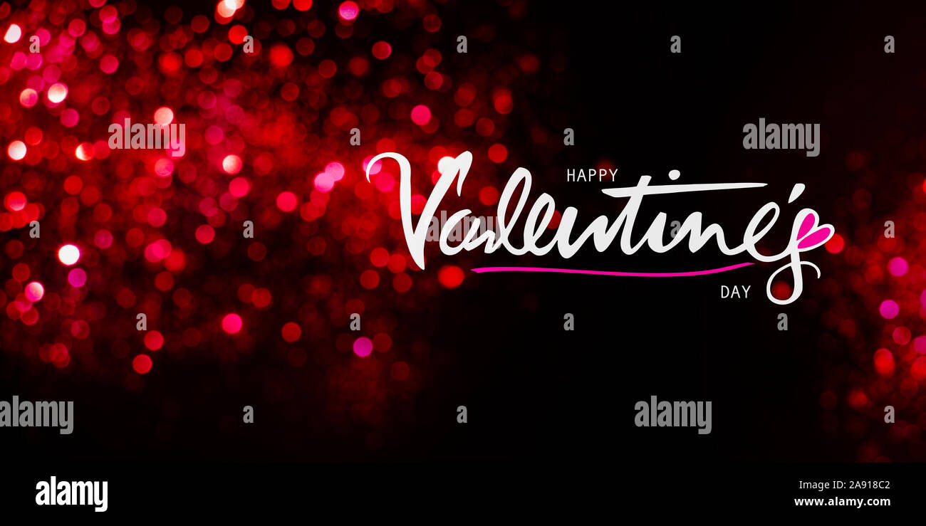 Happy Valentines Day écrit à la main le texte sur un fond rouge et noir avec des lumières scintillantes bokeh. Banque D'Images