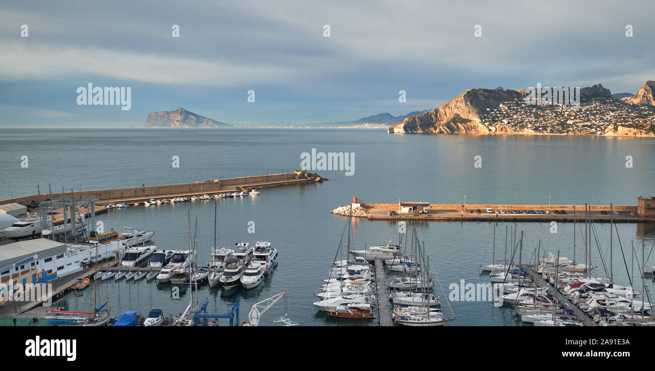 Vue d'un paysage pittoresque des montagnes Rocheuses dans le calme de la mer Méditerranée, yachts amarrés dans une rangée à port de ville touristique de Calpe, Espagne Banque D'Images
