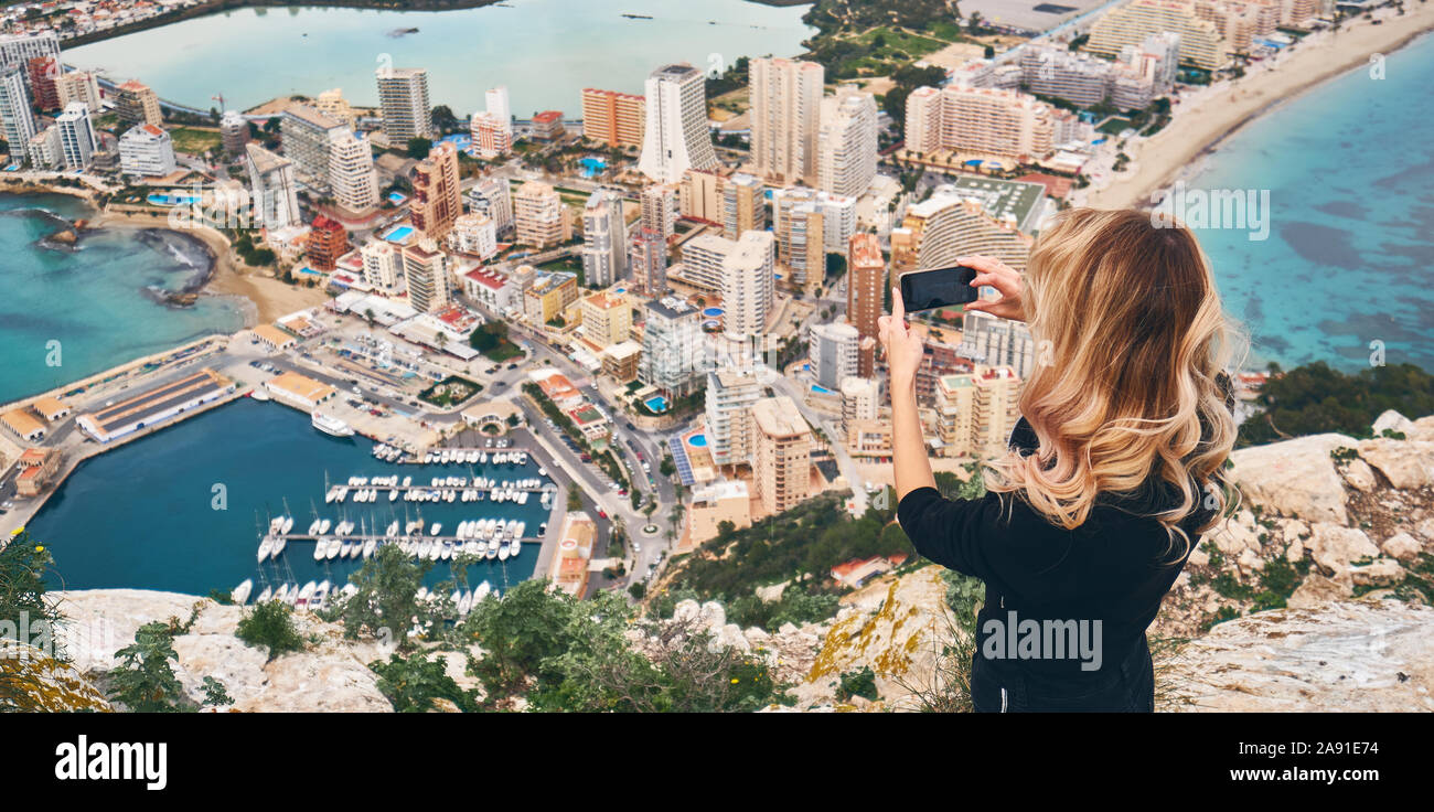 Femme grimpa sur Penon de Ifach. Profitez de la vue du haut de la ville, debout sur la montagne de pointe prend photo de paysage urbain et le paysage. Concept du tourisme Banque D'Images