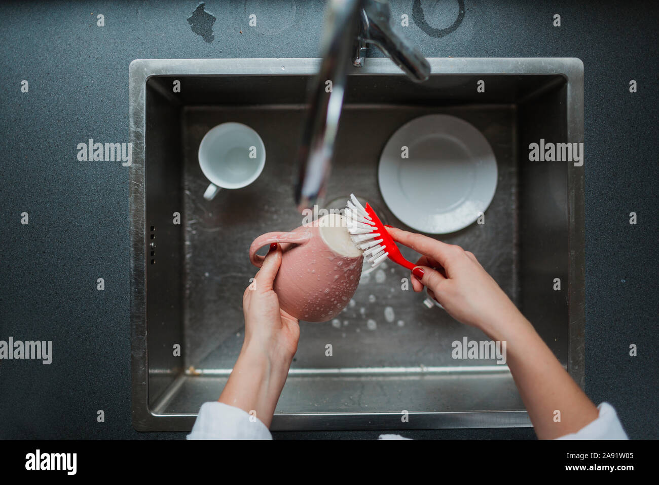 Woman washing up mug Banque D'Images