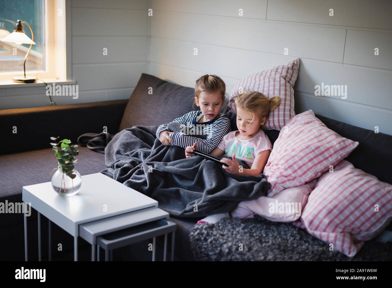 Sisters sitting on sofa Banque D'Images