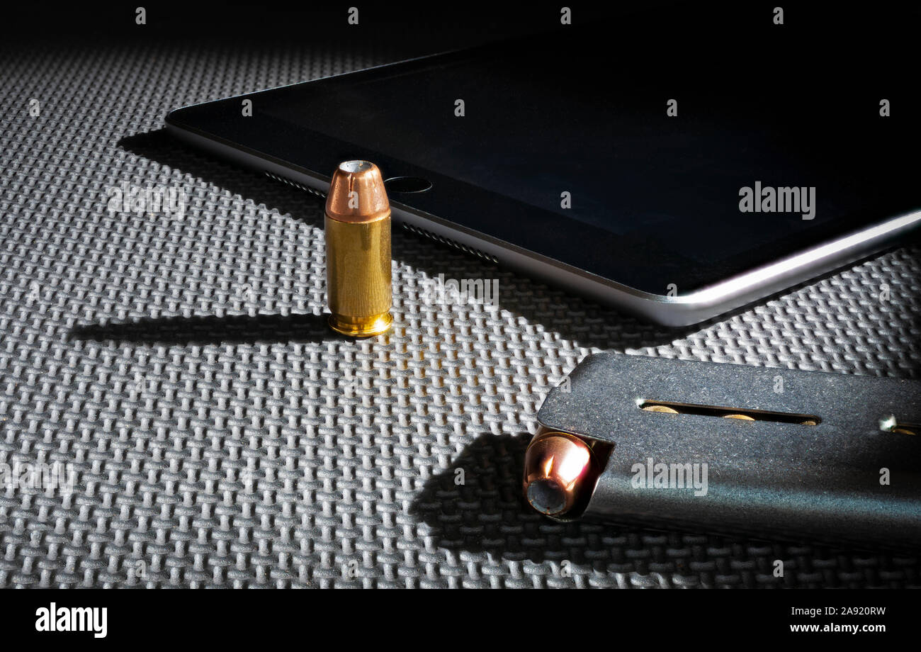 Des armes à feu et munitions à côté d'un magazine tablet Banque D'Images