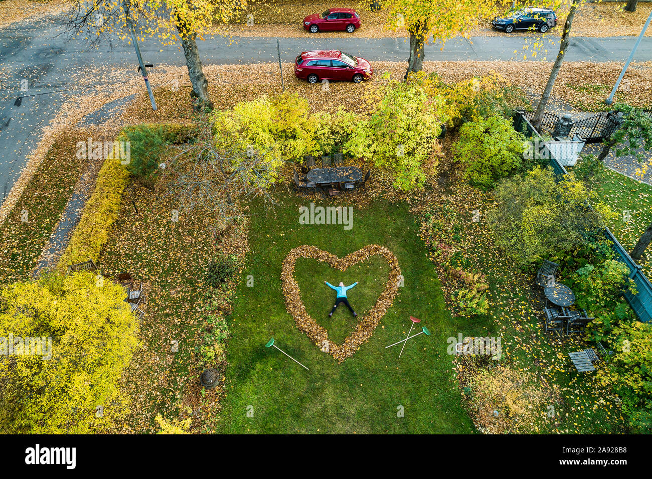 Personne couchée dans coeur faits de feuilles tombées Banque D'Images