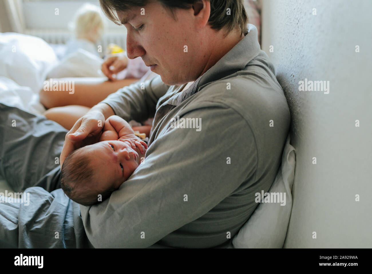 Père avec bébé au lit Banque D'Images