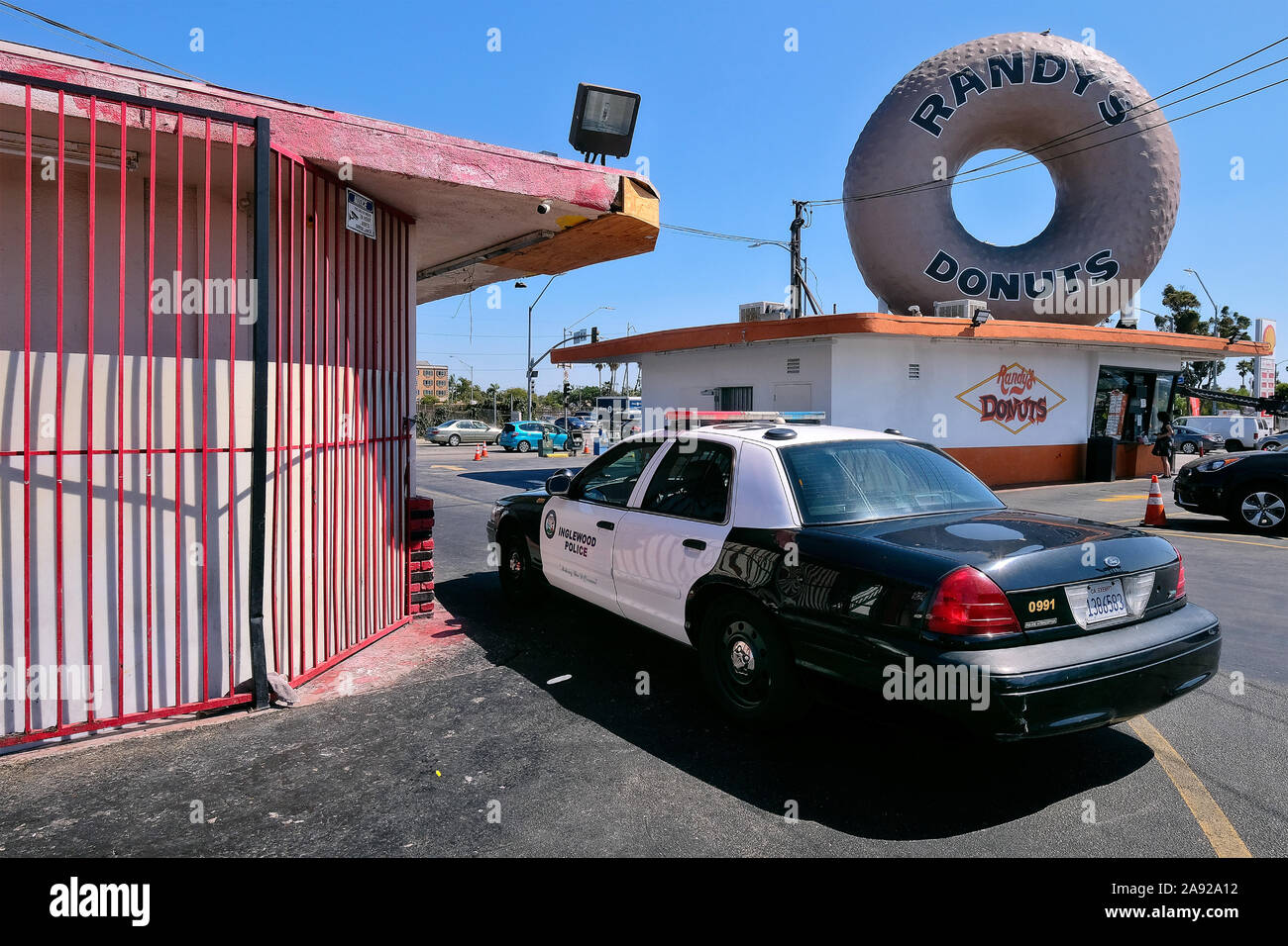 Voiture de police en face du légendaire donut snack 'Randy 's Donut' dans le quartier Inglewood, Los Angeles, Californie, USA Banque D'Images