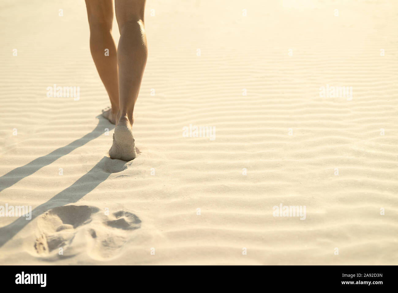 Woman walking on sand Banque D'Images