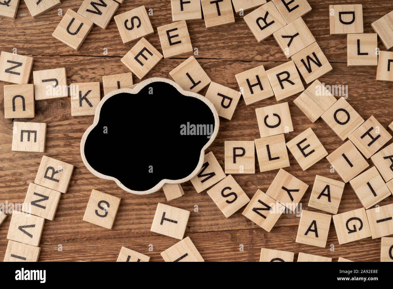 Un tableau vide et alphabets cube sur une surface en bois Banque D'Images