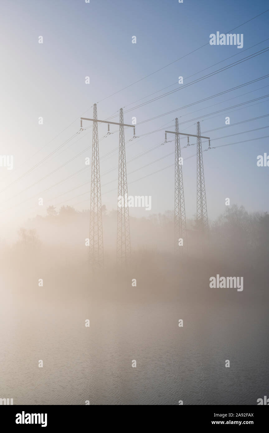 Pylônes électriques dans le brouillard Banque D'Images