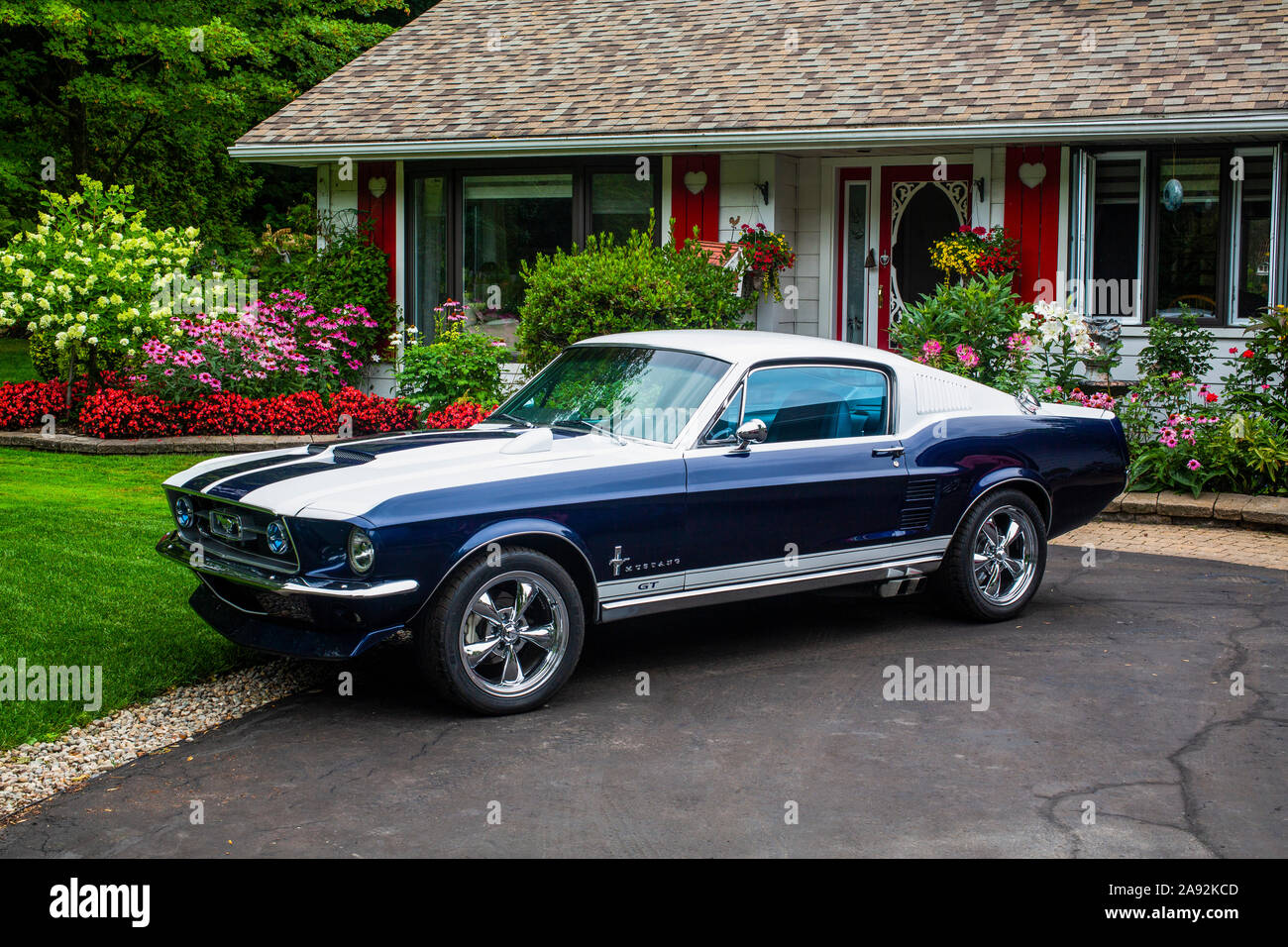 Voiture de sport garée à l'extérieur d'une maison aux fleurs; Hudson, Québec, Canada Banque D'Images