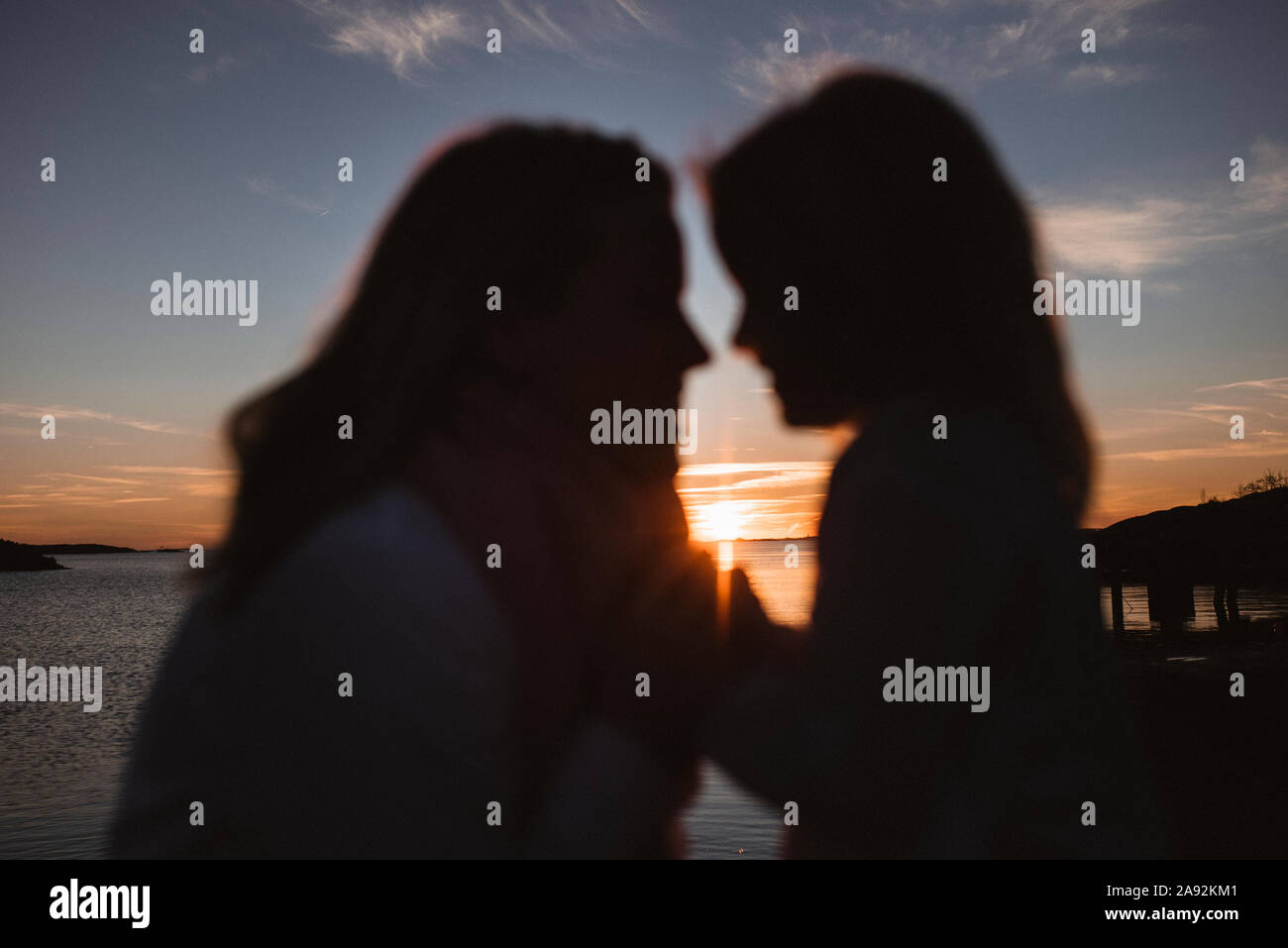 Silhouettes de mère et fille au coucher du soleil Banque D'Images