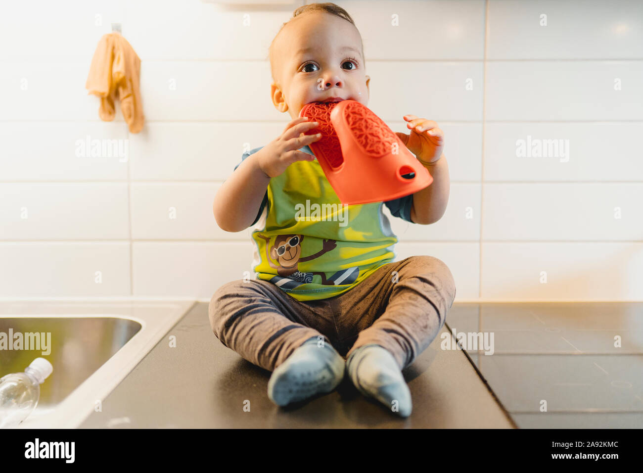 Baby Boy sitting sur plan de travail de cuisine Banque D'Images