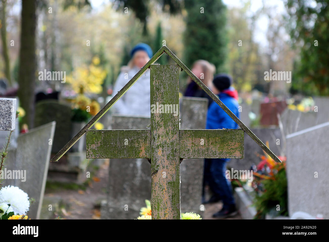 Vieille croix de bois dans un cimetière et la famille en arrière-plan sur la fête de la toussaint au 1er novembre et l'espace vide pour le texte Banque D'Images