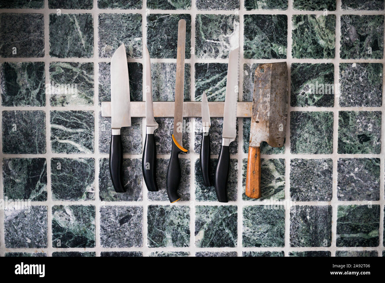 Couteaux de cuisine contre mur carrelé Banque D'Images