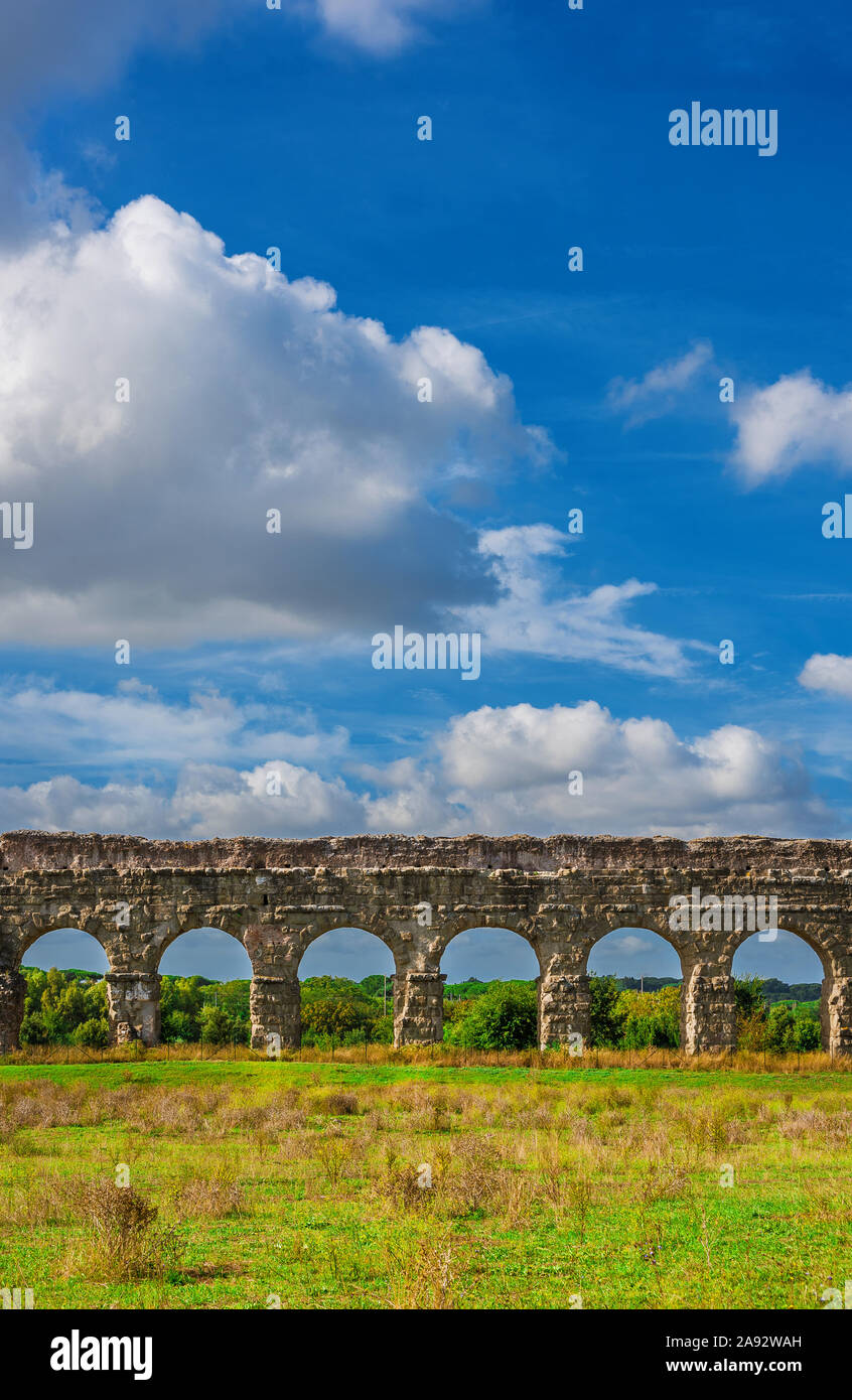 Ancien aqueduc romain ruines dans la campagne de Rome avec de beaux nuages au-dessus Banque D'Images