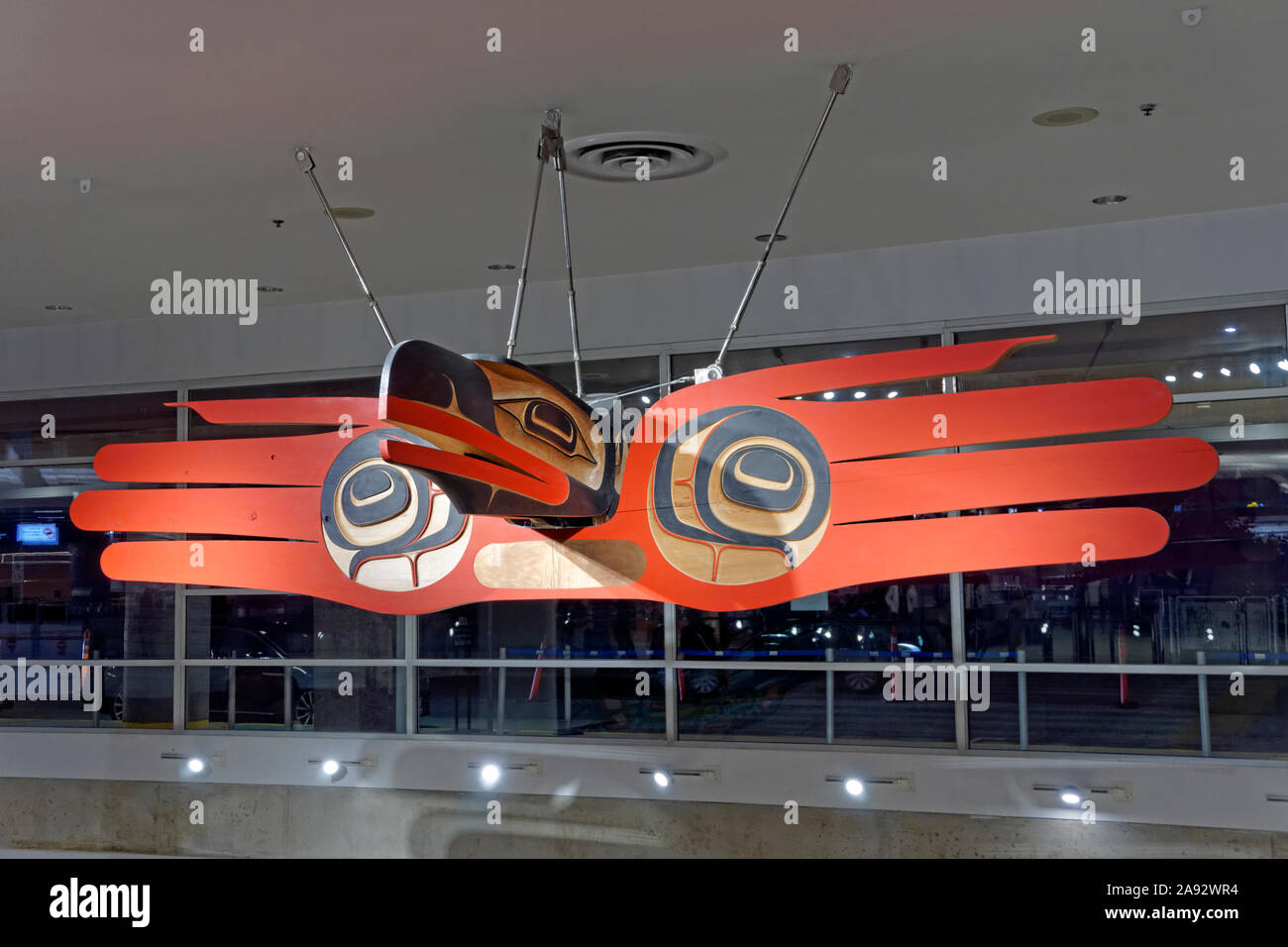 Serrant le monde par Robert Davidson sculpture en cèdre dans le terminal domestique de l'Aéroport International de Vancouver, Vancouver, BC, Canada Banque D'Images