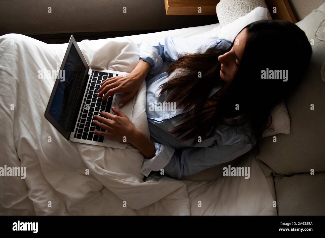 Woman using laptop in bed Banque D'Images