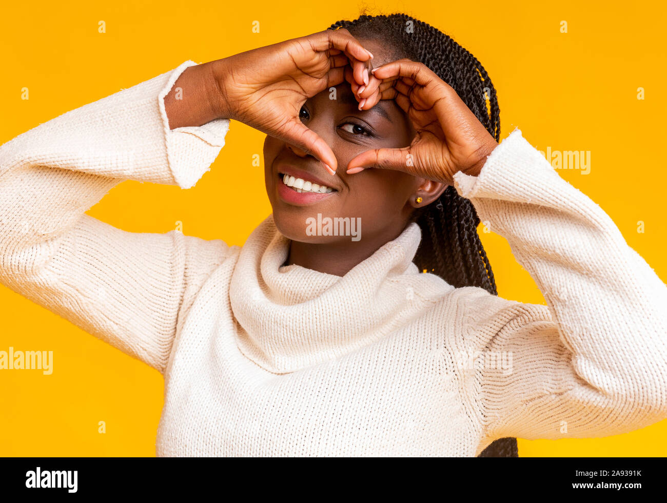 Jeune femme africaine heureux mains façonner comme coeur sur camera Banque D'Images