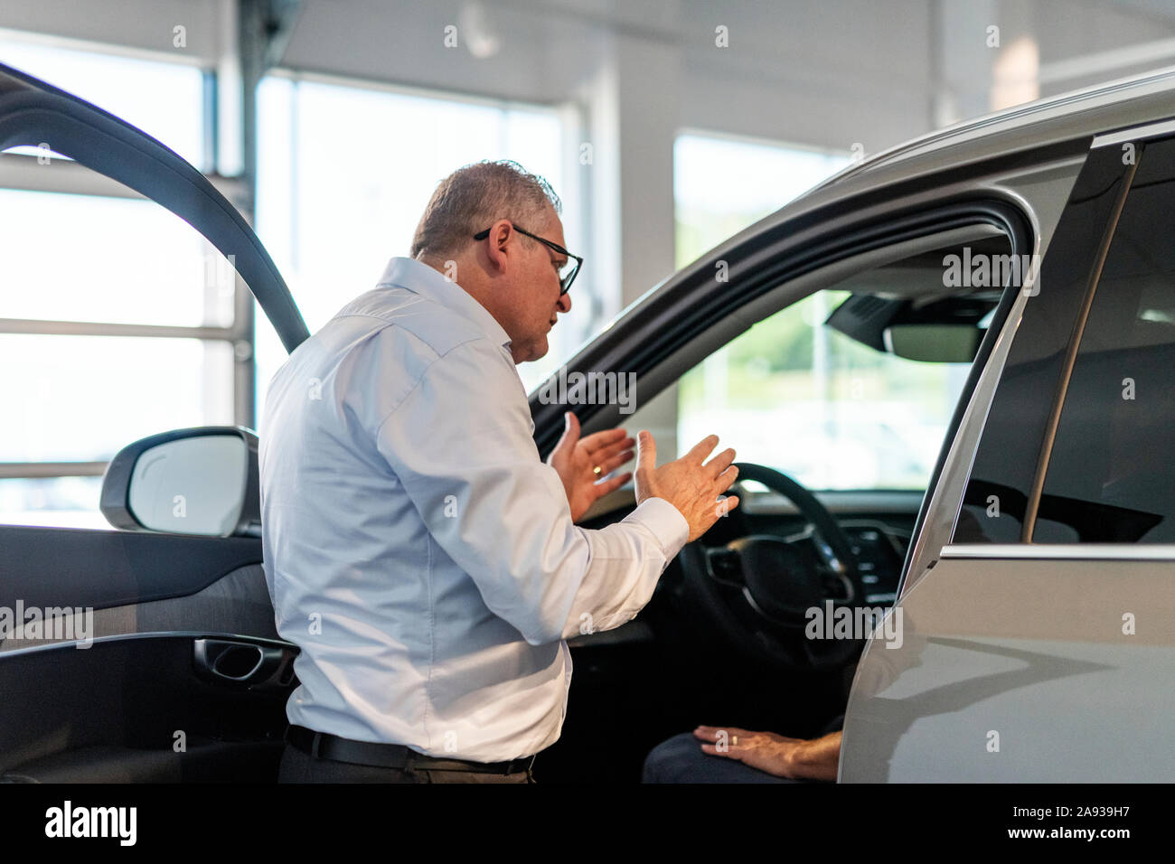 Salesman in car showroom Banque D'Images