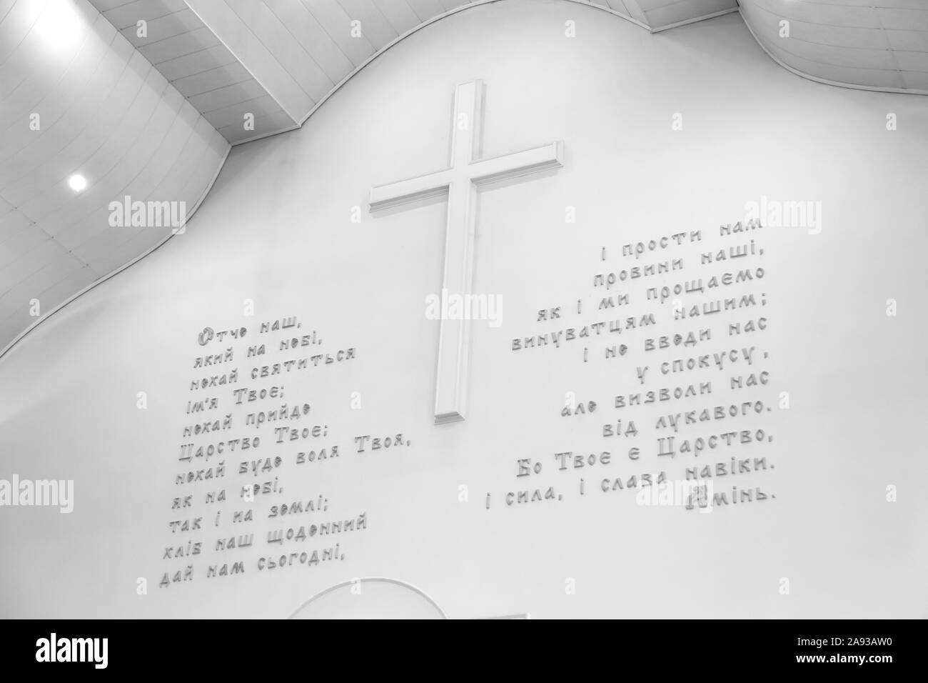 Thème de la Bible. Notre Père prière en ukrainien sur un mur blanc avec une grande croix Banque D'Images