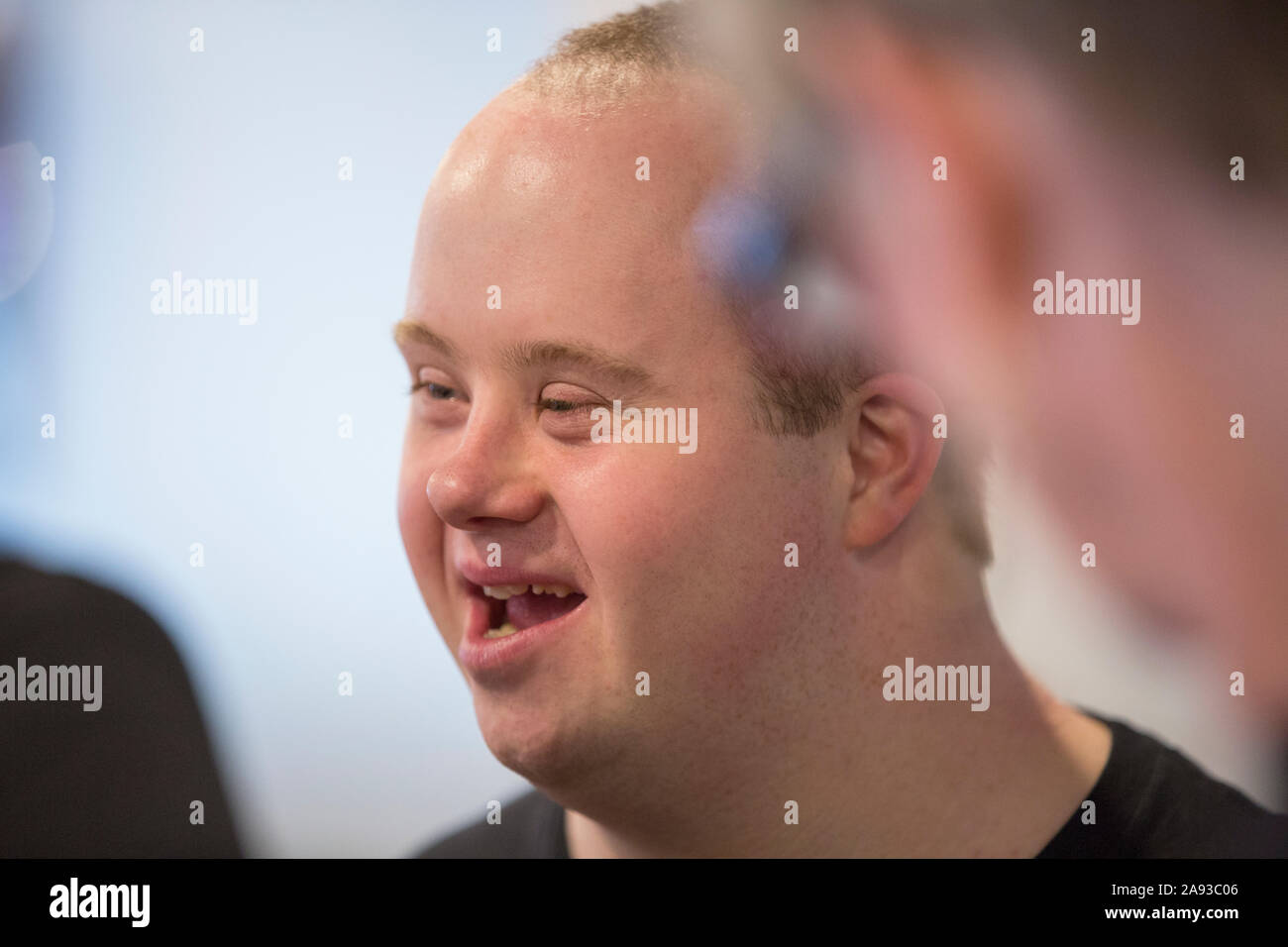 Garçon avec le syndrome de Down parler à d'autres collègues Banque D'Images