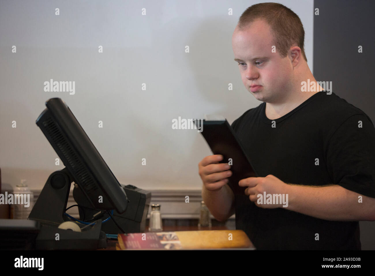 Garçon avec le syndrome de Down entrant dans une vente sur l'ordinateur Banque D'Images