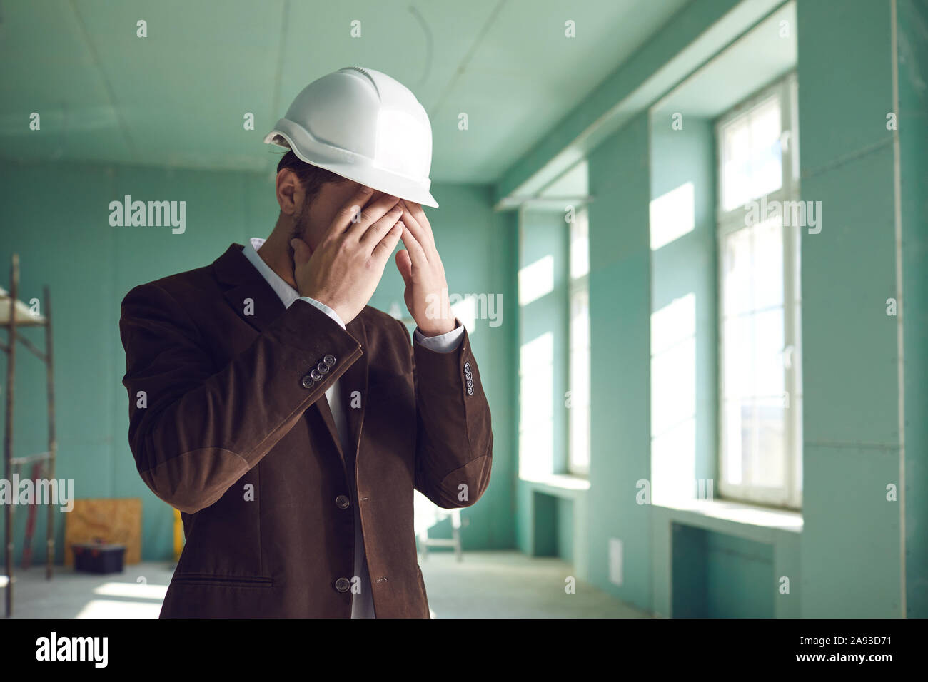 Foreman builder le visage couvert le problème du stress au travail sur le site de construction Banque D'Images
