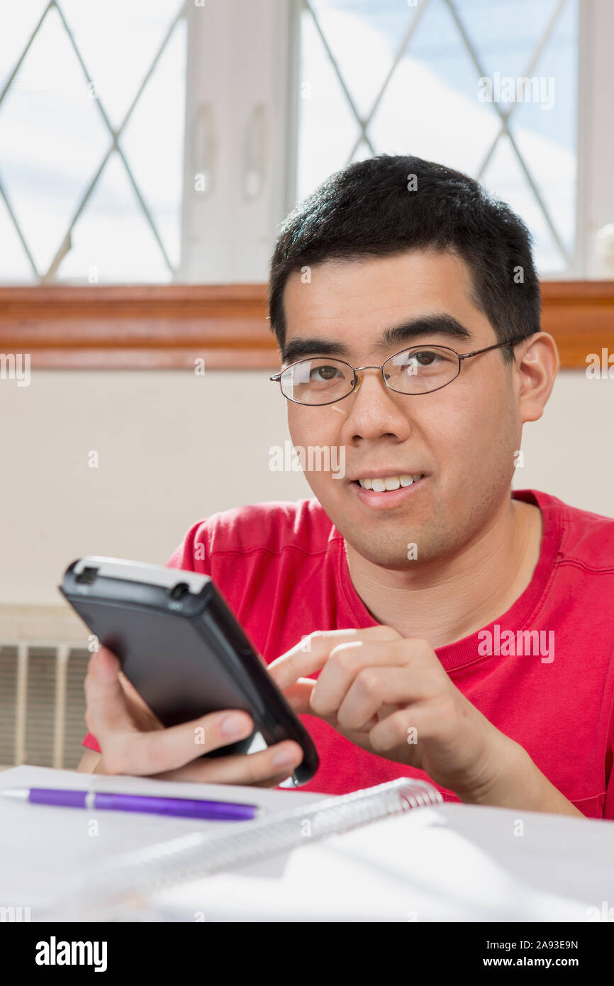Portrait de l'homme asiatique avec l'autisme travaillant sur sa cellule téléphone Banque D'Images