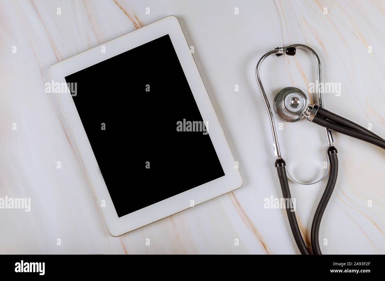 Ordinateur tablette numérique avec stéthoscope médical sur table de marbre sur le lieu de travail du bureau de l'hôpital médical Banque D'Images