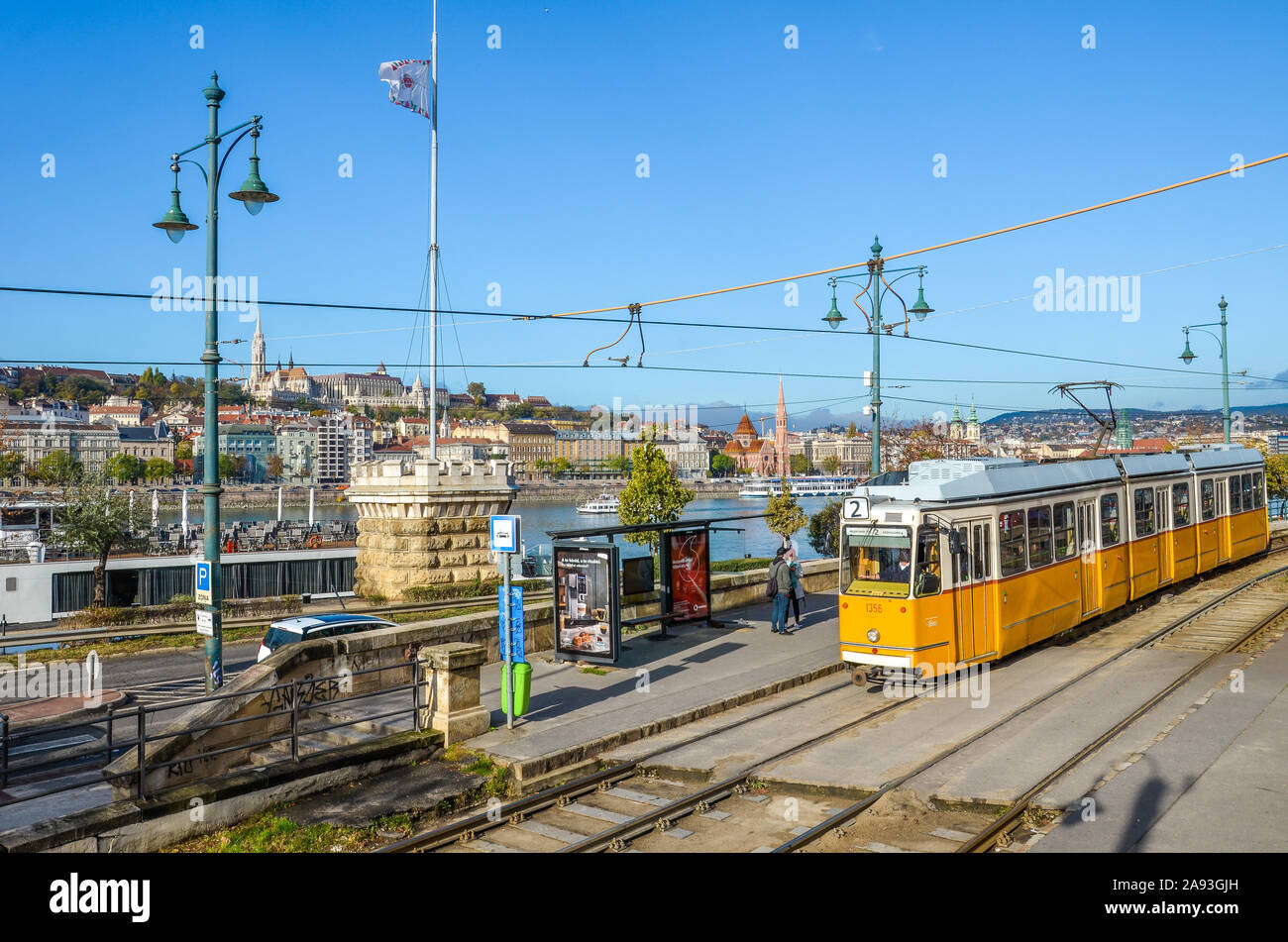 Paris, France - Nov 6, 2019 : tramway jaune à la station publique. Danube et le centre historique avec du Bastion des Pêcheurs et l'église Matthias en arrière-plan. Les gens de la rue. Journée ensoleillée. Banque D'Images