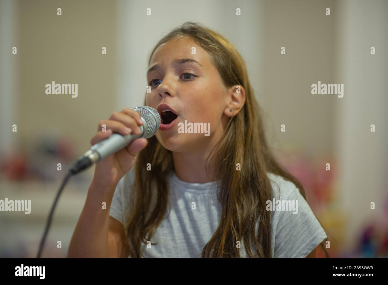 Enfant Fille Tenant Un Microphone Sans Fil Pour Chanter Ou Parler Au  Karaoké Et Haut-parleur Sur Fond Blanc