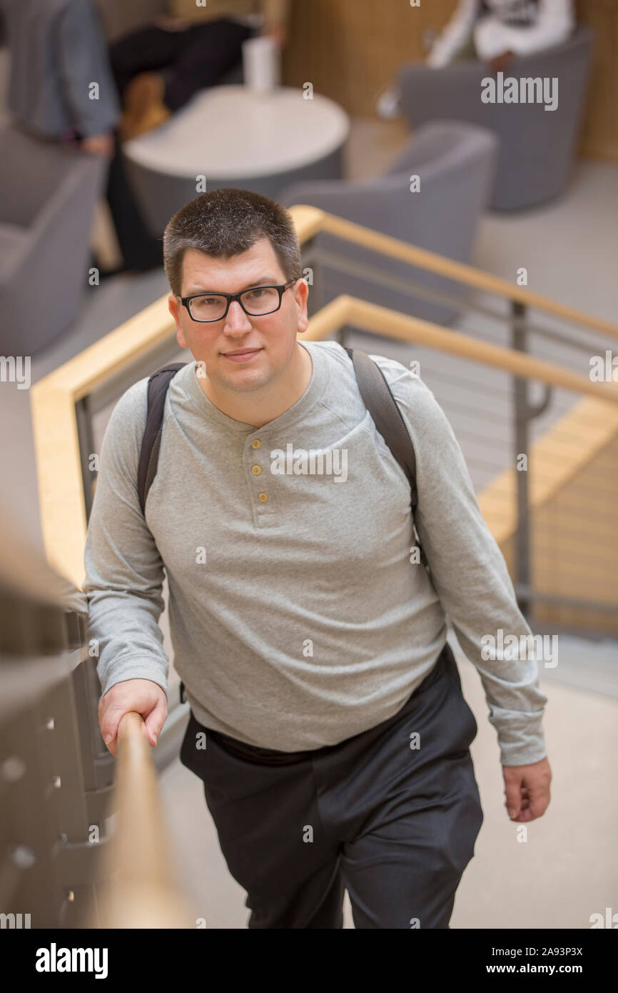Homme ayant une déficience visuelle qui se déplace vers le haut de l'escalier à l'école Banque D'Images