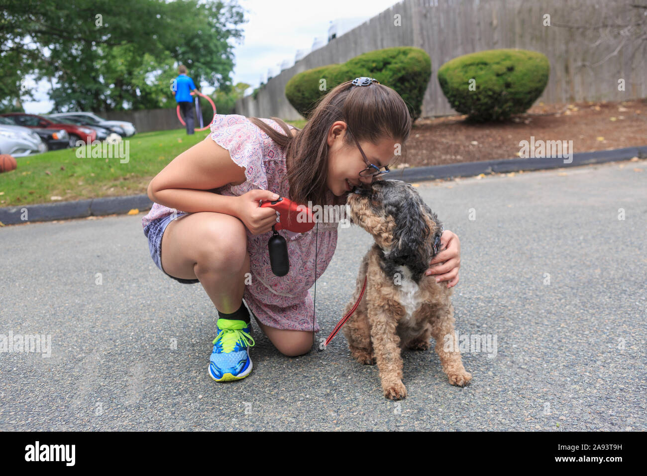 Jeune fille qui a un handicap d'apprentissage jouant avec son chien Banque D'Images