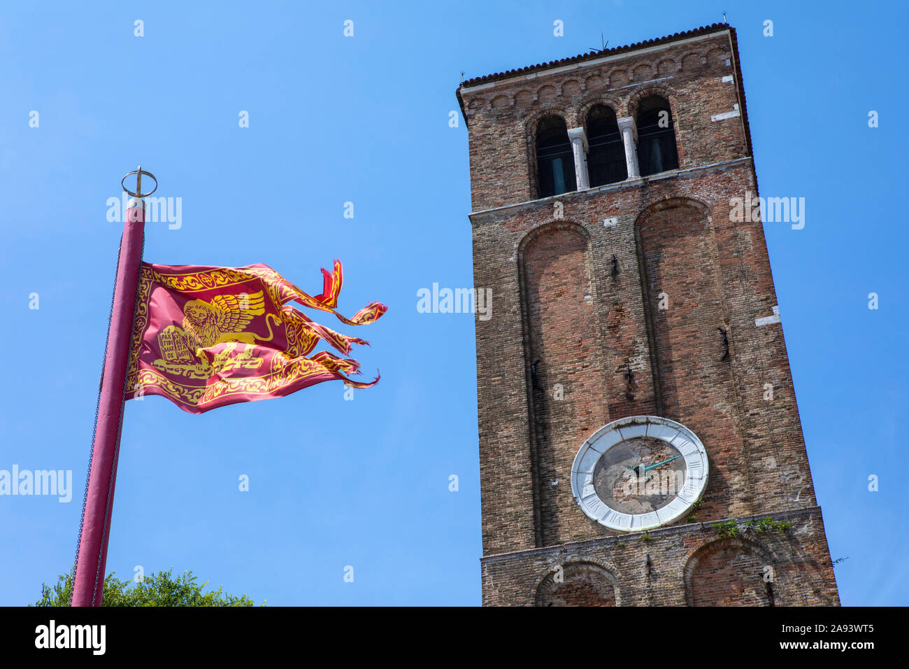 Le drapeau de Venise avec la tour de Santa Maria e San Donato église sur l'île vénitienne de Murano en Italie. Banque D'Images