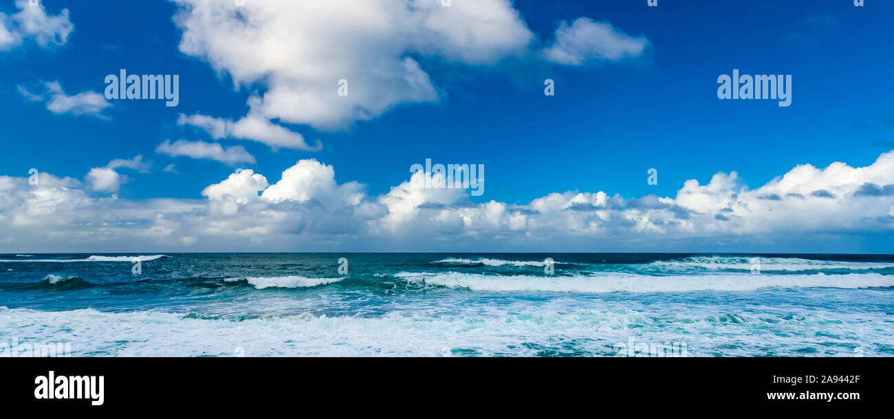 Les vagues de l'océan se déferle sur la rive avec l'horizon qui rencontre le nuage et le ciel bleu; Honolulu, Oahu, Hawaii, États-Unis d'Amérique Banque D'Images