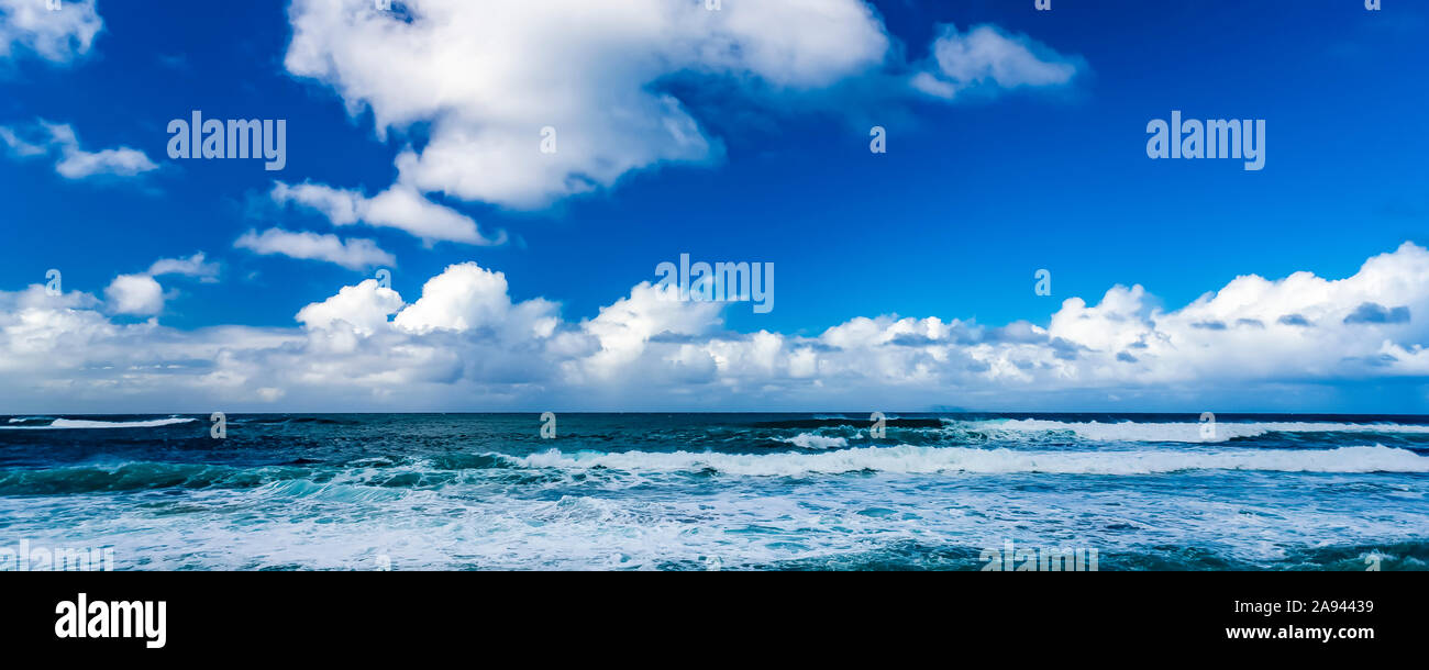 Les vagues de l'océan se déferle sur la rive avec l'horizon qui rencontre le nuage et le ciel bleu; Honolulu, Oahu, Hawaii, États-Unis d'Amérique Banque D'Images