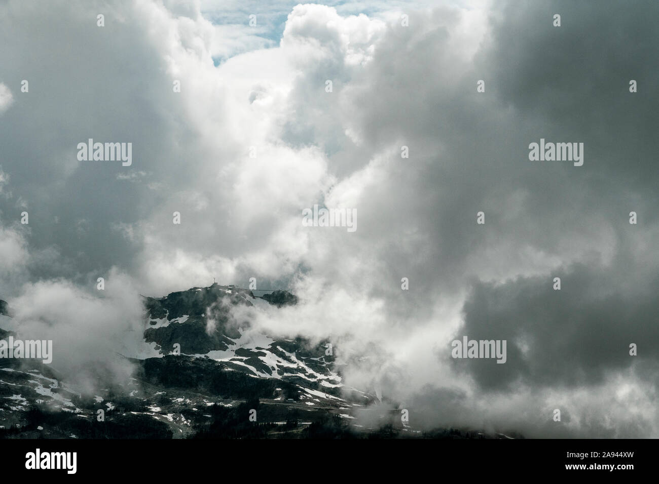 Vue panoramique du sommet de Whistler enveloppée de nuages sur un jour d'été orageux en Colombie-Britannique. Banque D'Images