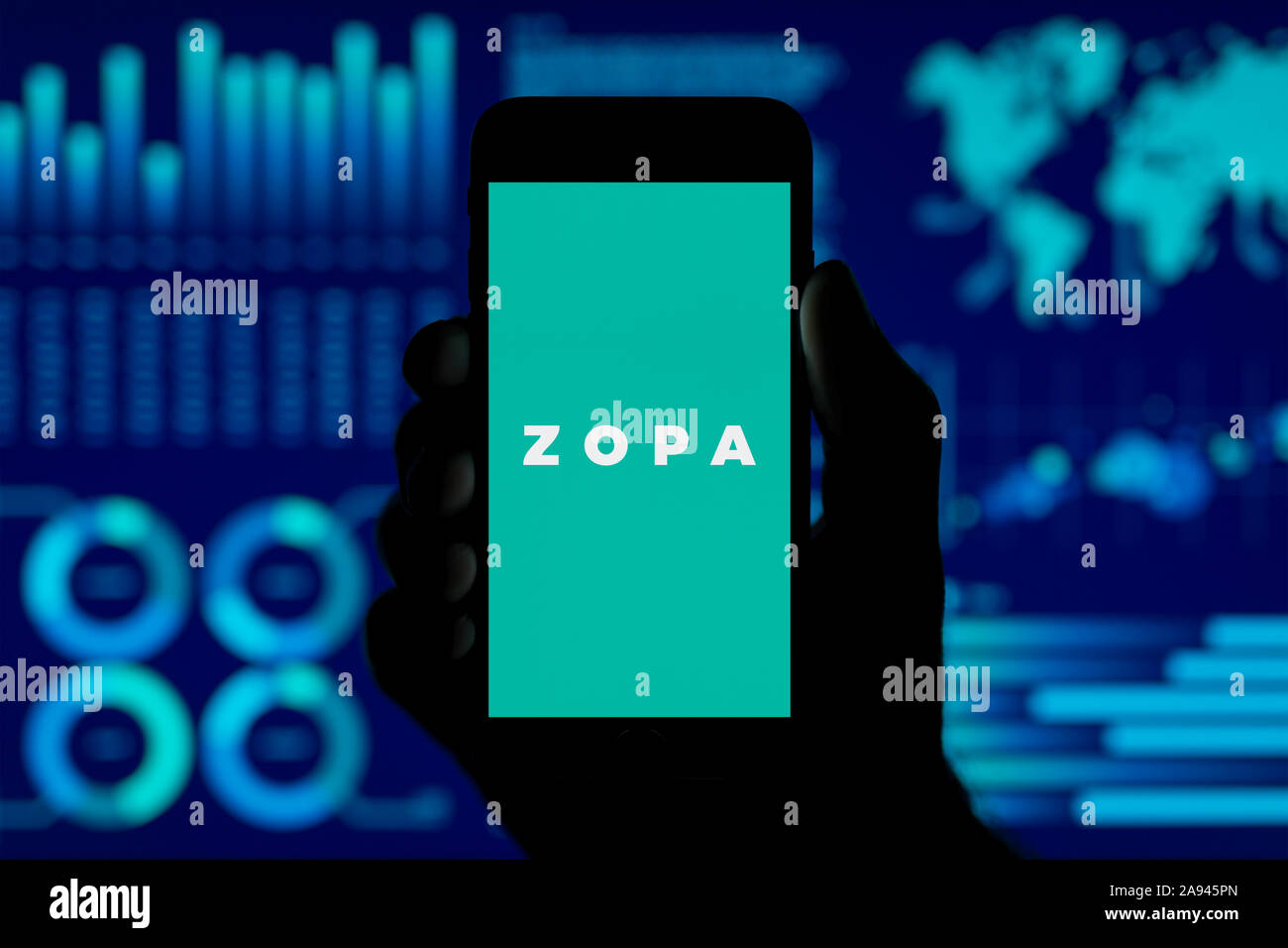 Un homme est titulaire de l'iPhone qui affiche le logo Zopa, tourné dans un style de visualisation de données (fond usage éditorial uniquement). Banque D'Images Un homme est titulaire de l'iPhone qui affiche le logo Zopa, tourné dans un style de visualisation de données (fond usage éditorial uniquement). Banque D'Images
