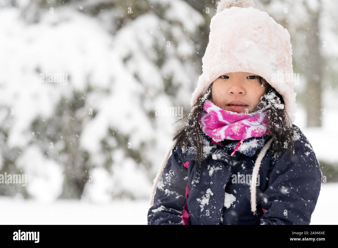 Portrait d'hiver d'un peu dans la neige fille asiatique Banque D'Images