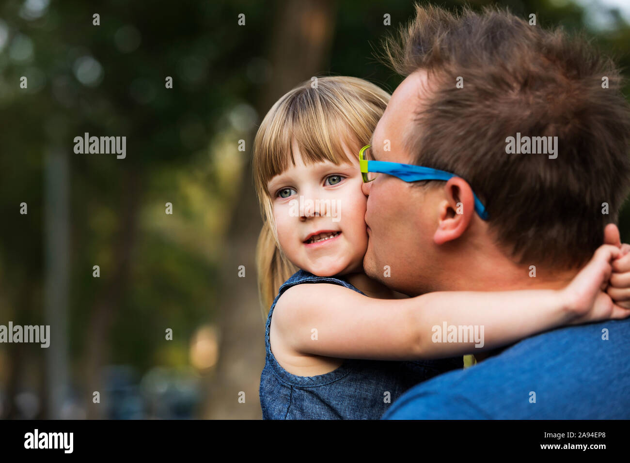 Portrait d'un père qui se coud avec sa jeune fille et l'embrasse sur la joue; Edmonton, Alberta, Canada Banque D'Images