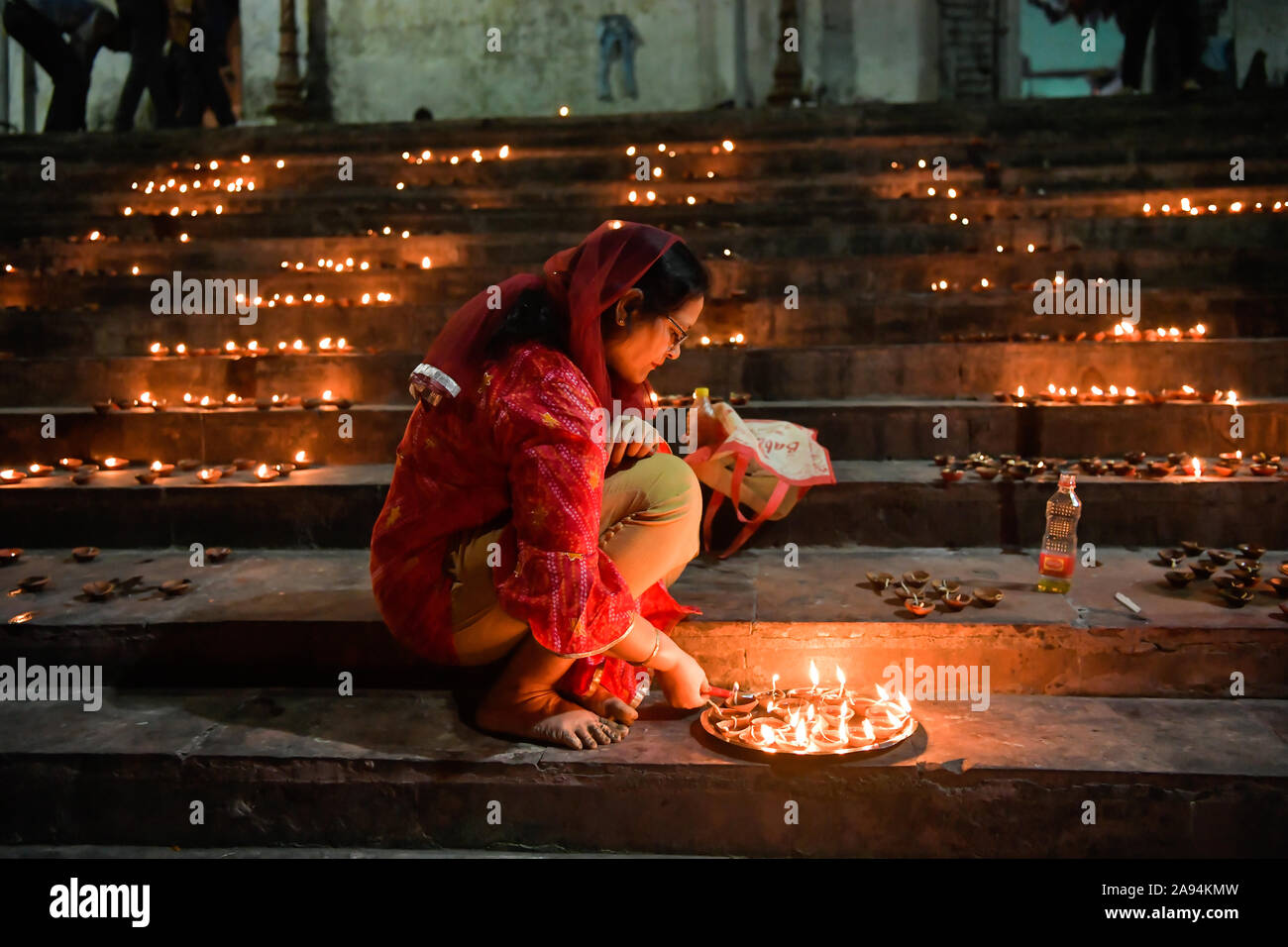 Kolkata, Inde. 12 Nov, 2019. L'éclairage d'une femme un bac plein de lampes en terre pour effectuer le rituel sur Dev Deepawali.Dev Deepawali est observée le jour de pleine lune (Purnima) dans le mois de Kartik après quatorze jours de Diwali. Credit : SOPA/Alamy Images Limited Live News Banque D'Images