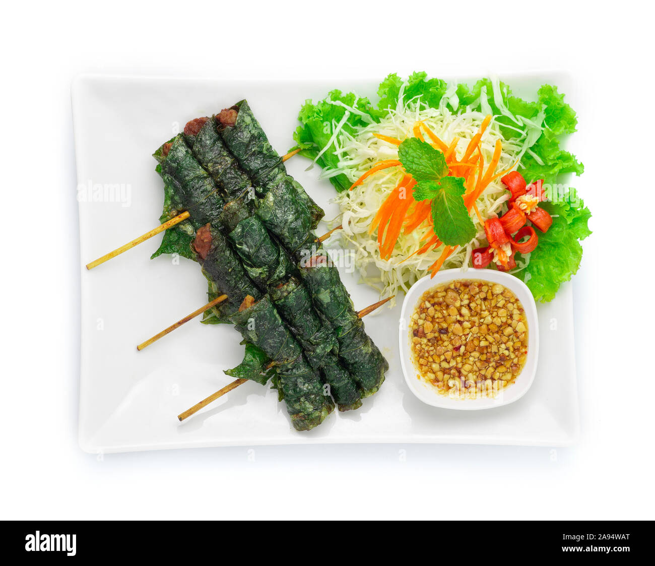 La nourriture vietnamienne porc frit enveloppés dans des feuilles sauvages vidéo à la demande au paiement à la sauce aux arachides sucrées servi mélange haché Fusion Food style vietnamien décorer avec un chou en tranches Banque D'Images
